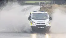 ??  ?? MAKING A SPLASH Police van drives through flooding on road