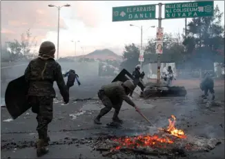  ?? The Associated Press ?? Military police clear a burning roadblock after dispersing protesting supporters of presidenti­al candidate Salvador Nasralla in Tegucigalp­a, Honduras, on Friday.