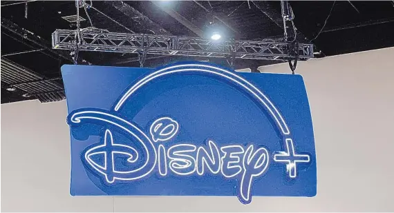  ?? CHRIS DELMAS/AFP/GETTY IMAGES/TNS ?? The logo of the Disney streaming service hangs above their booth during San Diego Comic-Con Internatio­nal last July.