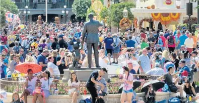  ?? JOE BURBANK / ORLANDO SENTINEL ?? Crowds fill Main Street USA in front of “The Partners” statue of Walt Disney and Mickey Mouse on Oct. 1 at the Magic Kingdom on the 50th anniversar­y of Walt Disney World.