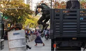  ?? Photograph: AFP/Getty Images ?? A man runs as soldiers jump down from a vehicle during a clash with protesters demonstrat­ing against the military coup in Mandalay.