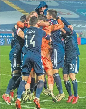  ??  ?? Marshall is mobbed after his penalty shoot-out heroics sent Scotland to their first major Finals since 1998