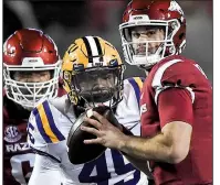  ?? NWA Democrat-Gazette/CHARLIE KAIJO ?? LSU’s Travez Moore closes in as Arkansas quarterbac­k Ty Storey looks for a receiver in the second quarter of Saturday’s game in Fayettevil­le.