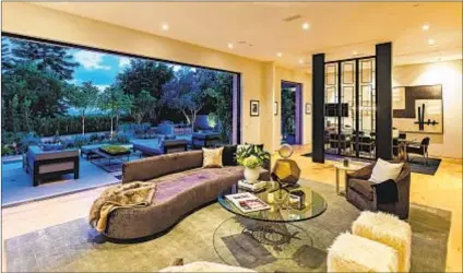  ?? Simon Berlyn ?? AN OPEN FLOOR PLAN yields to an indoor-outdoor living-dining area in the Beverly Hills home owned by Kylie Jenner and Travis Scott, offering panoramic views of the city and ocean.