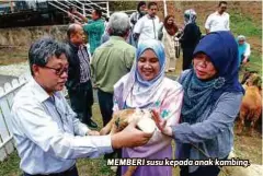  ??  ?? MEMBERI susu kepada anak kambing.