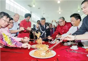  ?? GambarBern­ama ?? KHALID (lima, kiri) bersama tetamu jemputan menggaul ‘Yee Sang’ sempena sambutan Tahun Baru Cina di Ibu Pejabat Polis Kontinjen (IPK) Kuala Lumpur kelmarin. Turut hadir Ketua Polis Kuala Lumpur Datuk Amar Singh Ishar Singh (empat, kiri).