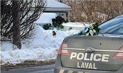  ?? Anne-Sophie Thill/AFP/Getty Images ?? White flowers lie on a police car near the location where a city bus crashed into a daycare center, in Laval, Quebec, Canada. Photograph: