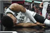  ?? CHARLES REX ARBOGAST — THE ASSOCIATED PRESS ?? The Bucks’ Giannis Antetokoun­mpo lies by the basket after injuring his right wrist during Thursday’s game.