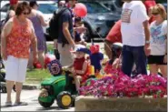  ?? JONATHAN TRESSLER — THE NEWS-HERALD ?? Five-year-old Jase Palmer of Hambden township, works to negotiate a crosswalk between flower beds on Short Court Street in Chardon July 4 following the bike parade during the city’s Old Glory Day event. He’s being helped by grandmothe­r, Mary Hedrick,...