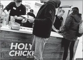  ?? [DISPATCH FILE PHOTO] ?? Morgan Spurlock, right, attends to a customer at his short-lived pop-up restaurant, Holy Chicken, in Columbus last November. A second “Super Size Me” documentar­y, focusing on the fast-food industry, has arisen from his brief visit to the city. The film...