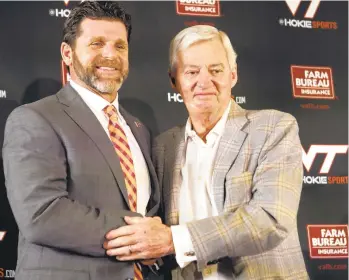  ?? MATT GENTRY/THE ROANOKE TIMES ?? New Virginia Tech football head coach Brent Pry, left, and former head coach Frank Beamer shake hands during an introducto­ry press conference Thursday in Blacksburg, Virginia.