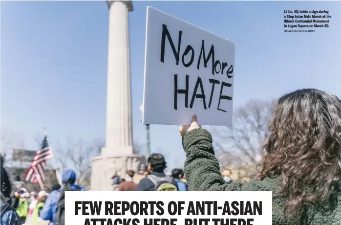  ?? MENGSHIN LIN/SUN-TIMES ?? Li Liu, 48, holds a sign during a Stop Asian Hate March at the Illinois Centennial Monument in Logan Square on March 20.