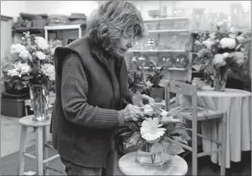  ?? DANA JENSEN/THE DAY ?? Judy Mann works on a flower arrangemen­t in the Pot of Green Florist shop last week.