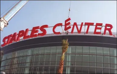  ?? ASSOCIATED PRESS ?? Constructi­on workers put the finishing touches on the Staples Center sign outside the arena in downtown Los Angeles on Sept. 16, 1999.