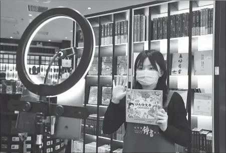  ?? REN CHAO / XINHUA ?? A saleswoman promotes a book via livestream­ing platforms at a bookstore in Beijing on March 18.