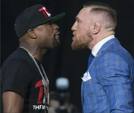  ?? RICK MADONIK, TORONTO STAR ?? Floyd Mayweather, left, and Conor McGregor egg each other on Wednesday in front of a packed house at the Budweiser Stage of Molson Amphitheat­re.