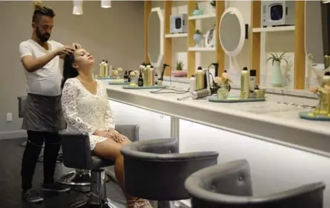  ?? AARON HARRIS FOR THE TORONTO STAR ?? Raquel Nero has her hair done by George Gogos at the café/spa Her Majesty’s Pleasure that’s in her King St. W. condominiu­m building, Fashion House.