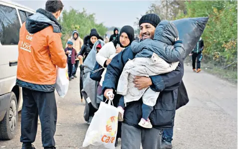  ??  ?? A helping hand: refugees from the conflict in Syria receive practical assistance from CARE Internatio­nal, which operates in 75 developing countries across the world