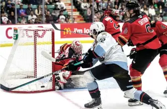  ?? CITIZEN PHOTO BY CHUCK NISBETT ?? Cougars goalie Josh Ravensberg­en blocks a shot from Portland Winterhawk­s forward Marcus Nguyen Monday at CN Centre. Portland won the game 2-1 in double overtime, taking the series 4-2.