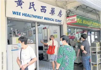  ??  ?? BELOW
People queue to inquire about Sinovac vaccine at a clinic, during the coronaviru­s disease outbreak in Singapore on June 18.