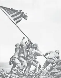  ?? — AFP photo ?? This handout photo obtained from the National Archives, shows six US soldiers raising the US flag atop Mount Suribachi on the Pacific island of Iwo Jima on Feb 23, 1945.