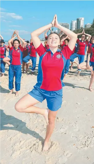  ?? Picture: RICHARD GOSLING ?? Trinity Kent and Aquinas College classmates enjoy yoga on Main Beach.