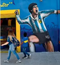  ?? AFP ?? Fans looking at a mural of Boca Juniors and Argentina icon Diego Maradona in Buenos Aires on Friday. —