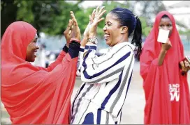  ?? SUNDAY ALAMBA / ASSOCIATED PRESS ?? Bring Back Our Girls campaigner­s celebrate the release of the kidnapped Chibok schoolgirl­s at the unity fountain in Abuja, Nigeria, on Sunday. Five Boko Haram commanders were released in exchange for the 82 girls.