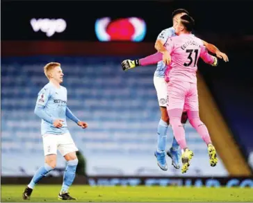  ?? POOL/AFP ?? Manchester City’s Brazilian goalkeeper Ederson (right) and Spanish midfielder Rodrigo (centre) celebrate after its German midfielder Ilkay Gundogan (not pictured) scored the team’s third goal during their English Premier League football match against Tottenham Hotspur on Saturday.