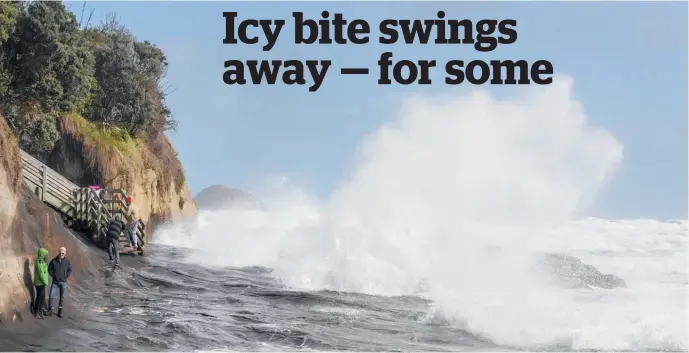  ?? Photos / Peter Meecham, Flor Montaruli ?? Jonny and Debbie Webster from Te Atatu scan the wild surf at Muriwai Beach in West Auckland. Below, Flor Montaruli enjoys the snow in Invercargi­ll.