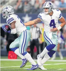  ?? AFP ?? The Cowboys’ Dak Prescott, right, hands the ball to Ezekiel Elliott.