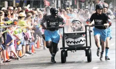  ?? The Sentinel-Record/Lorien E. Dahl ?? AUTO JAWS: Members of the Riser Ford Lincoln “Jaws Returns” team are sprayed with water guns during the 12th annual Stueart Pennington Running of the Tubs Saturday in downtown Hot Springs.