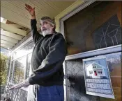  ??  ?? Greg Flood, a resident of Seattle’s Wallingfor­d neighborho­od, stands on the porch of his two-story Craftsman home and talks about a proposal to allow three- to five-story housing to be built on his block.