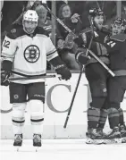  ?? KARL B DEBLAKER/AP ?? The Hurricanes’ Jaccob Slavin, center, celebrates his goal with teammate Seth Jarvis, right, as the Bruins’ Craig Smith, left, skates away during the first period on Tuesday in Raleigh, N.C.