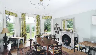  ??  ?? Main picture right, owners Phil and Sarah Bucknall in the kitchen at Stow House – the table is made from scaffoldin­g boards; above, the snug/ library is painted in Farrow & Ball’s Pelt; left, the breakfast room boasts sensationa­l views; below right,...