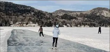  ?? Anne Kenderdine / The Washington Post ?? Figure skaters stroke westward on the half-mile-long skating trail on the frozen Lake Morey in Fairlee, Vt., in January.