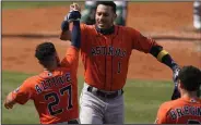  ?? (AP/Ashley Landis) ?? Carlos Correa (center) is congratula­ted by Houston teammates Jose Altuve and Alex Bregman after hitting a two-run home run Monday in a 10-5 victory over the Oakland Athletics in Game 1 of the American League division series in Los Angeles. Correa had two home runs and drove in four runs.