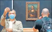  ?? AFP ?? ■ A visitor wearing a face mask takes a selfie in front of Leonardo da Vinci's masterpiec­e Mona Lisa at the Louvre Museum in Paris.