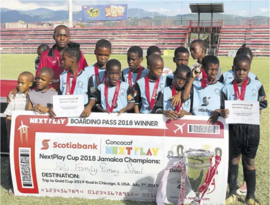  ??  ?? Members of the winning Holy Family Primary team pose with a symbolic boarding pass for their trip to this summer’s Concacaf Gold Cup Final in Chicago on July 7.