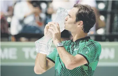  ?? Picture: AFP ?? ON A ROLL. Roger Federer of Switzerlan­d kisses the Miami Masters trophy after he beat Rafael Nadal in the final at the Crandon Park Tennis Centre on Sunday.