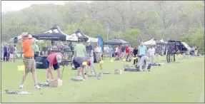  ?? Keith Bryant/The Weekly Vista ?? Golfers line up to try out new equipment during Bella Vista’s first-ever Golf Fest at the Tanyard Creek practice area.