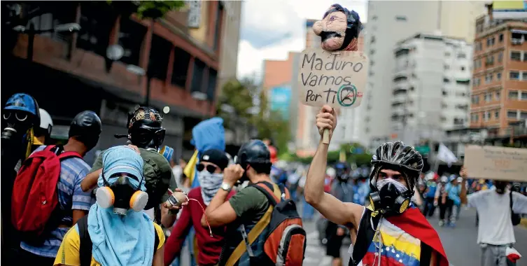  ?? REUTERS ?? Opposition supporters rally against Venezuela’s President Nicolas Maduro’s government in the capital, Caracas, yesterday. The banner reads: "Maduro, we are going for you."