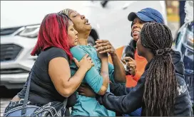  ?? JOHN SPINK/JSPINK@AJC.COM / FILE ?? A distraught Sanmarian McClain is comforted after her 18-year-old daughter was killed by an apparently stray bullet as gunfire struck their southwest Atlanta home on Oct. 3. No suspects have been arrested.