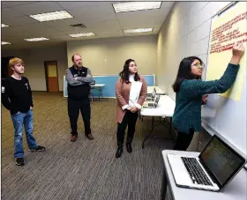  ?? NWA Democrat-Gazette/FLIP PUTTHOFF ?? Sidra Nadeem (right) and Katherine Caceres (second from right), students at New Technology High School, take comments Wednesday from residents including Payne Brewer (center) at the Community in Action meeting in Rogers.