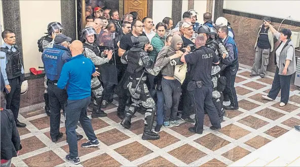  ?? [ AFP ] ?? Gewalt im Parlament. Mazedonisc­he Polizisten versuchen die Schlägertr­upps zu stoppen, die in das Gebäude der Volksvertr­etung in Skopje eingedrung­en sind.