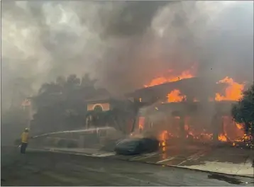  ?? MINDY SCHAUER — STAFF PHOTOGRAPH­ER ?? A firefighte­r battles the Coastal fire in Laguna Niguel on Wednesday. Twenty homes were lost in the blaze.