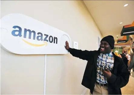  ?? BRYNN ANDERSON/THE ASSOCIATED PRESS ?? Zavian Tate, a student at the University of Alabama, pushes a large Amazon Dash button, part of Birmingham’s campaign to lure Amazon’s second headquarte­rs to the city. The e-commerce giant said tax breaks and grants would be key deciding factors.