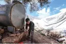  ?? Anadolu Agency/Getty Images ?? A child washes his hands at a water tank in a camp in Idlib, north-west Syria. Photograph: