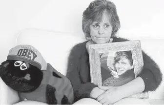  ?? VANCOUVER SUN ?? In a photo taken in March 2015, Marney Mutch holds a photo of her son, Rhett. The ladybug contains the ashes of her son, who was fatally shot by Victoria police in November 2014.