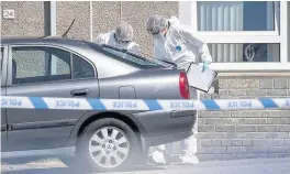  ??  ?? INVESTIGAT­ION Police in forensics gear look for clues at scene of incident